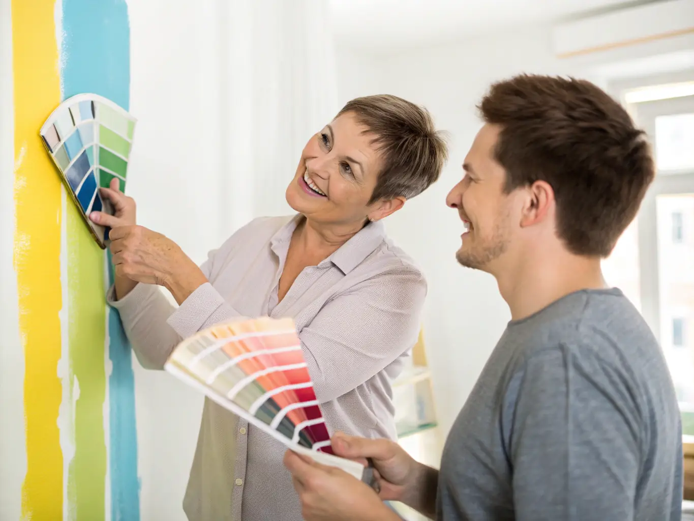 A color consultant presents a homeowner with a variety of paint swatches and color palettes, discussing the best options for their home's interior. The setting is a bright, modern living room.